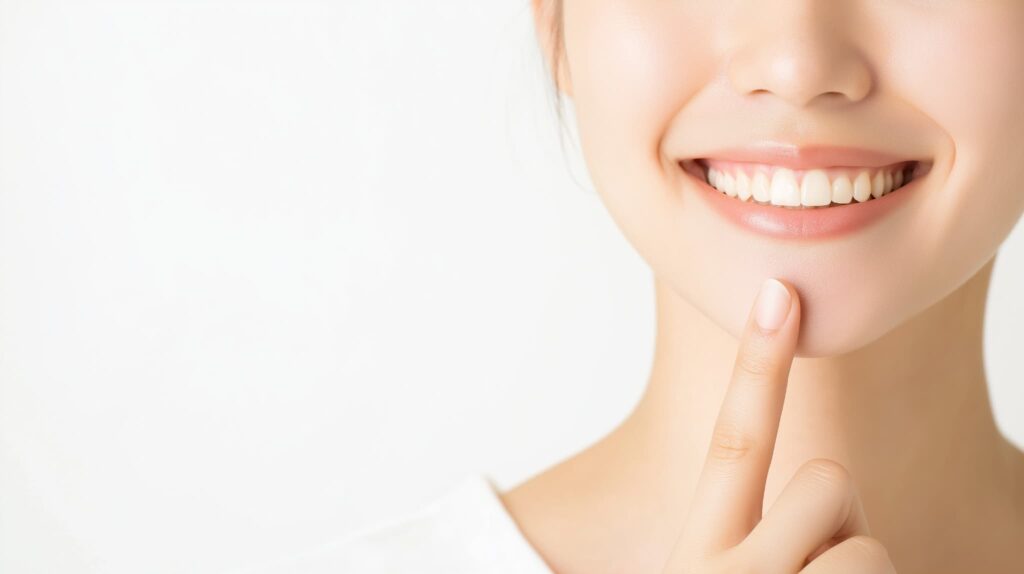 白い歯を指さす女性